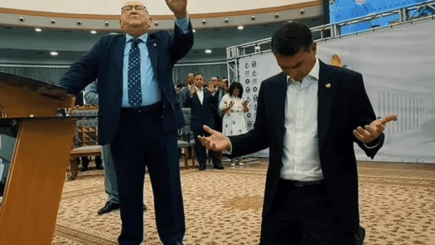 Durante a oração, o bispo fez referência ao futuro político do senador; na imagem, pastor José Wellington Costa Júnior (esq.) ora por Flávio Bolsonaro (dir.)... Leia mais no texto original: (https://www.poder360.com.br/poder-gente/flavio-bolsonaro-recebe